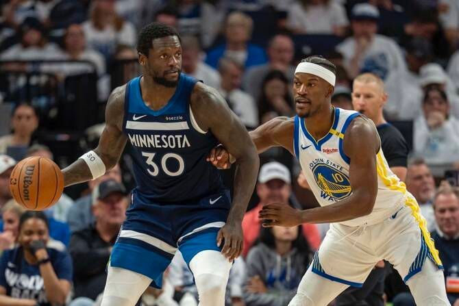 Two basketball players are playing a game of basketball on a court.