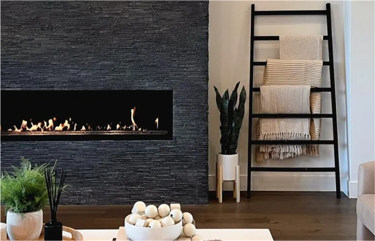 A living room with a fireplace and a ladder.