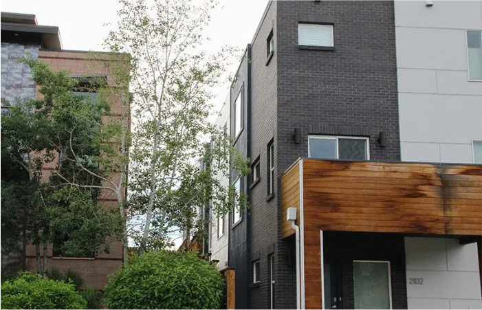 A brick building with a wooden roof sits next to another building