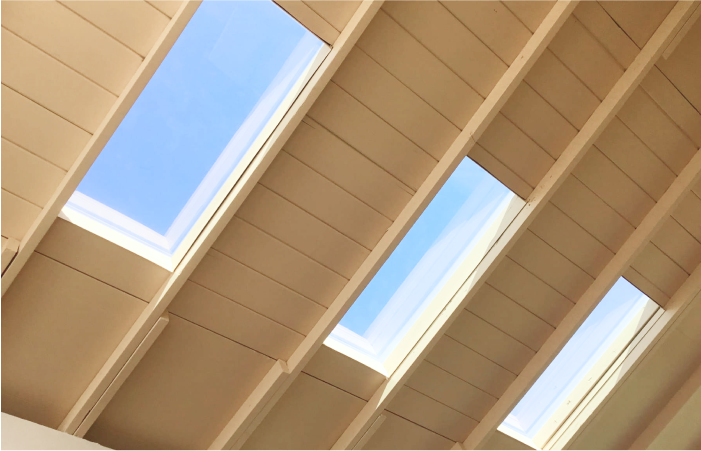 Looking up at a ceiling with three skylights