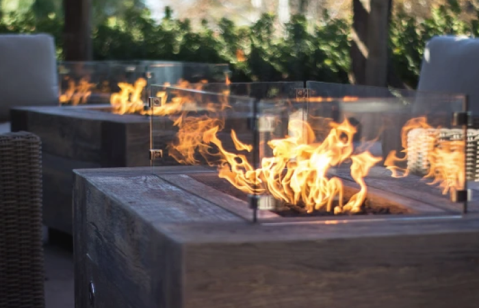 A fire pit is sitting on top of a wooden table.