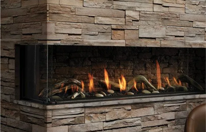 A fireplace with a brick wall behind it is lit up.