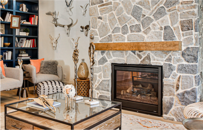 A living room with a fireplace and a glass coffee table.