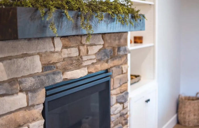 A fireplace with a stone mantle in a living room.