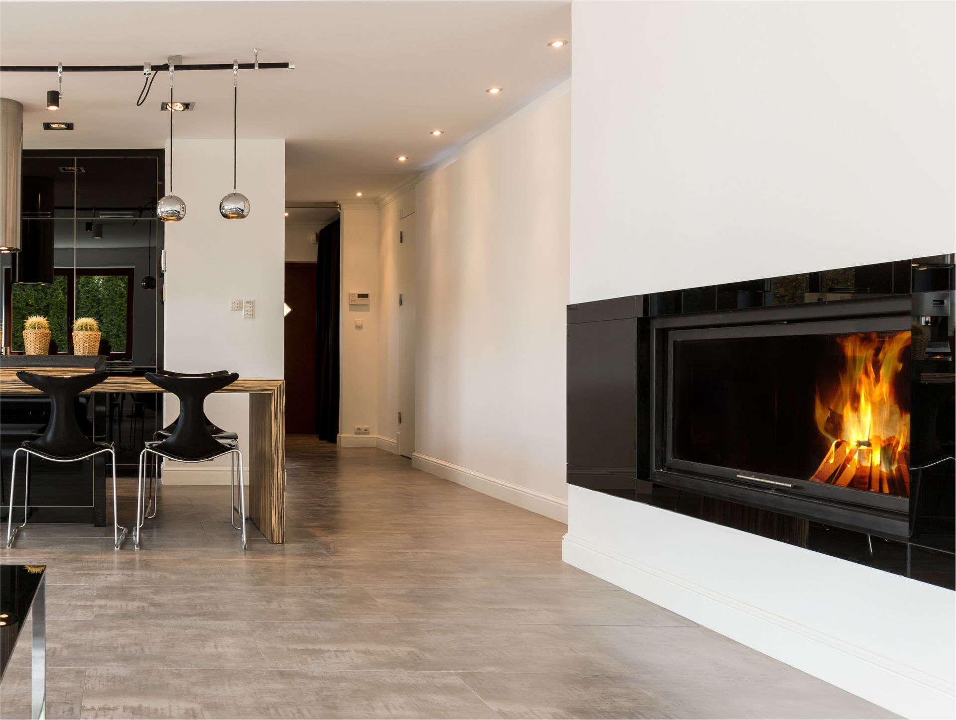 A living room with a fireplace and a dining room in the background.