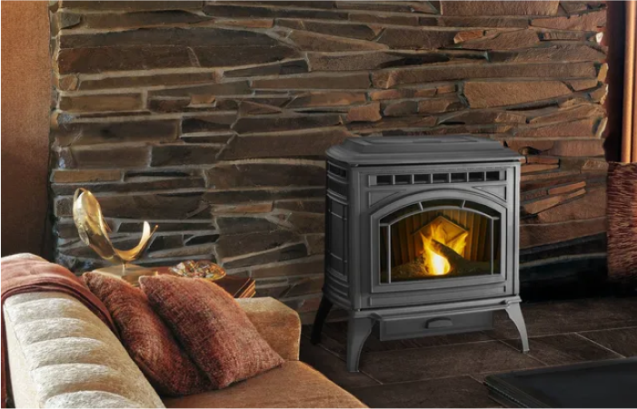 A wood stove is sitting in a living room next to a couch.