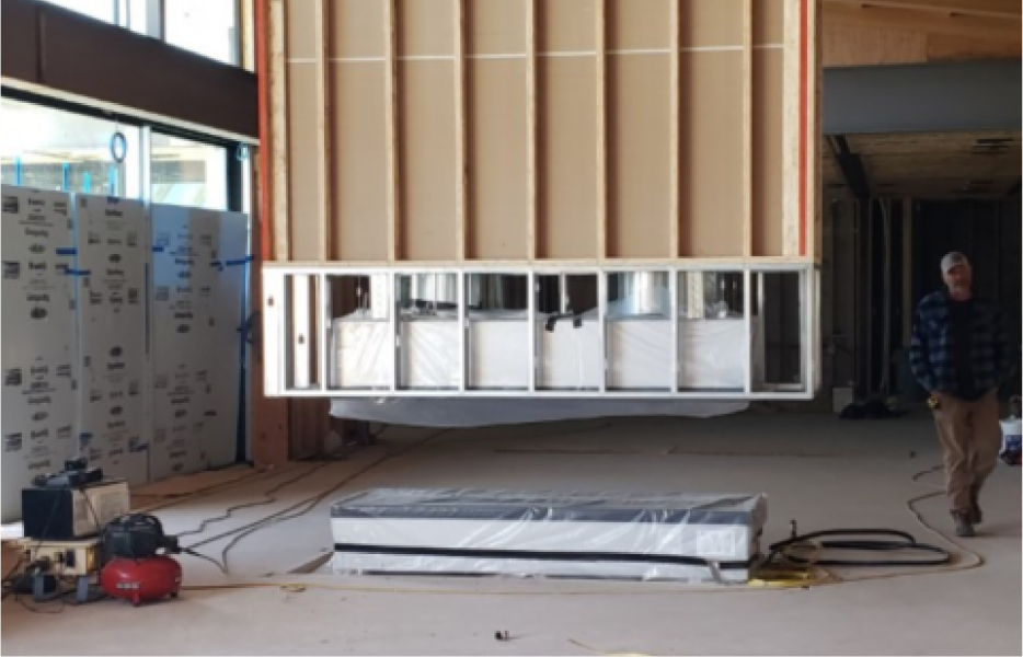 A man is standing in front of a building under construction.