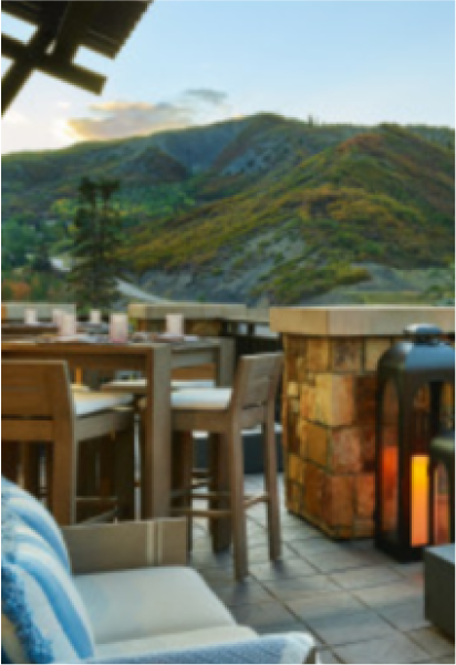 A patio with a view of mountains and a table and chairs