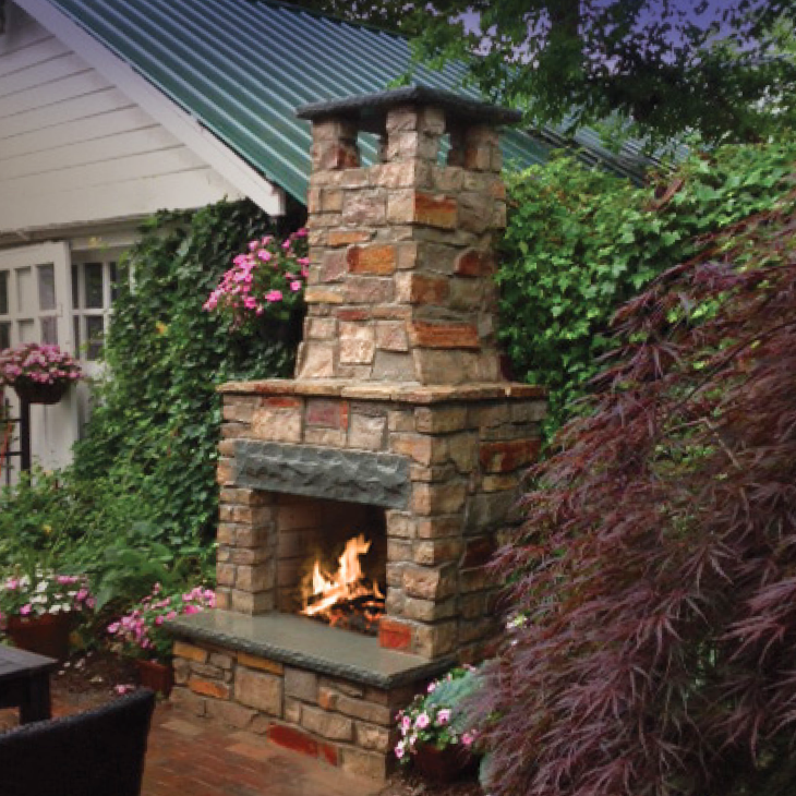 A stone fireplace with a chimney on top of it
