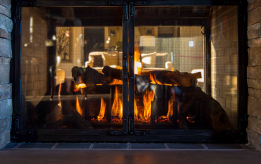 A fireplace with a mantle and a lot of logs in it.