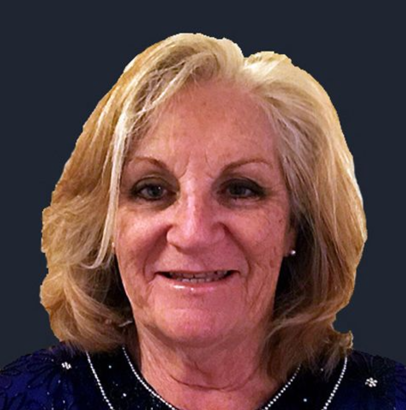 A woman with blonde hair is smiling and wearing a blue shirt