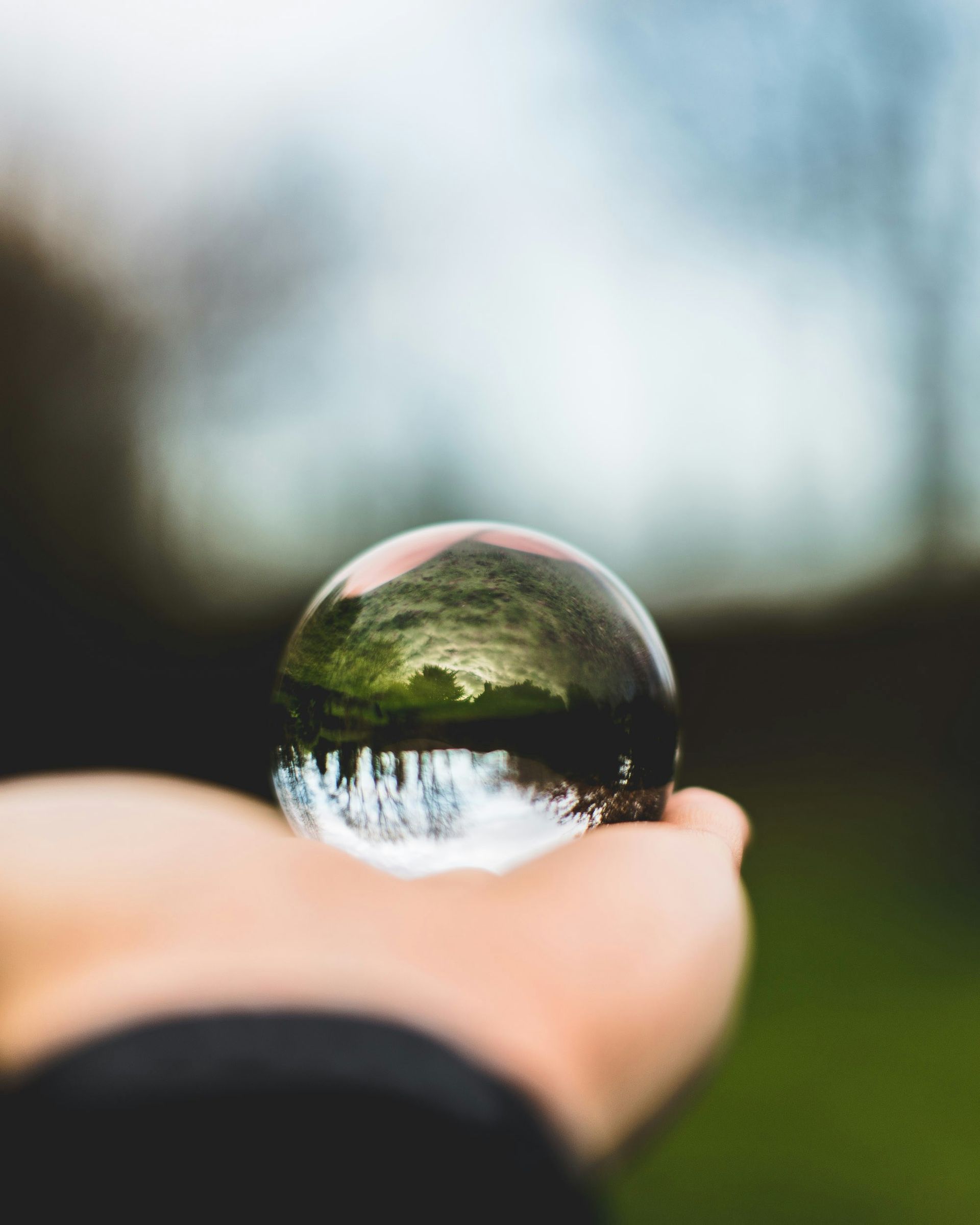 A person is holding a glass ball in their hand.