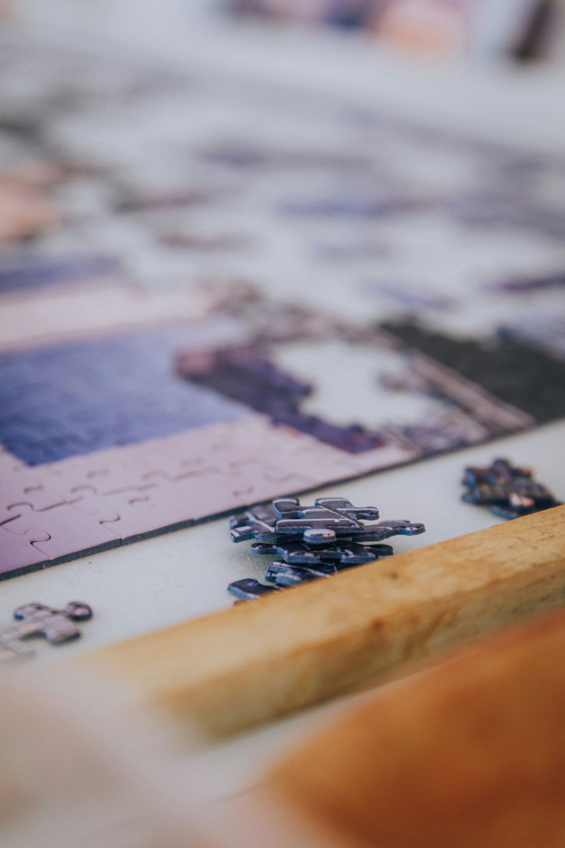 A close up of a person playing a puzzle on a table.
