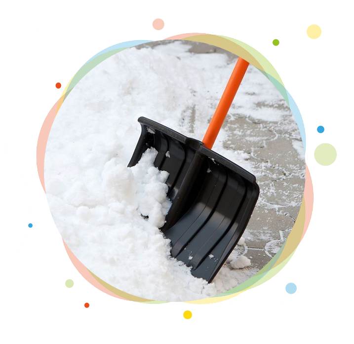Snow shovel with orange handle clearing snow from a paved surface.