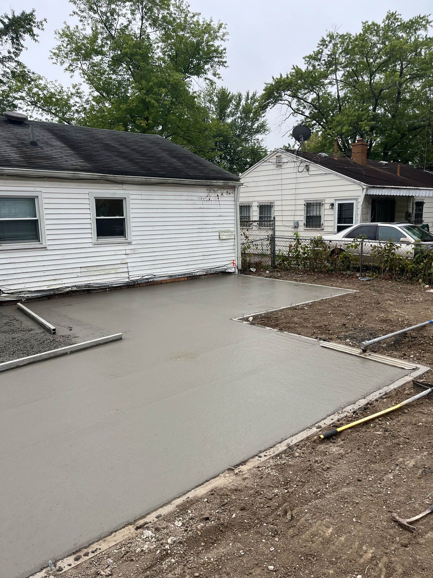 A concrete driveway is being built in front of a house.