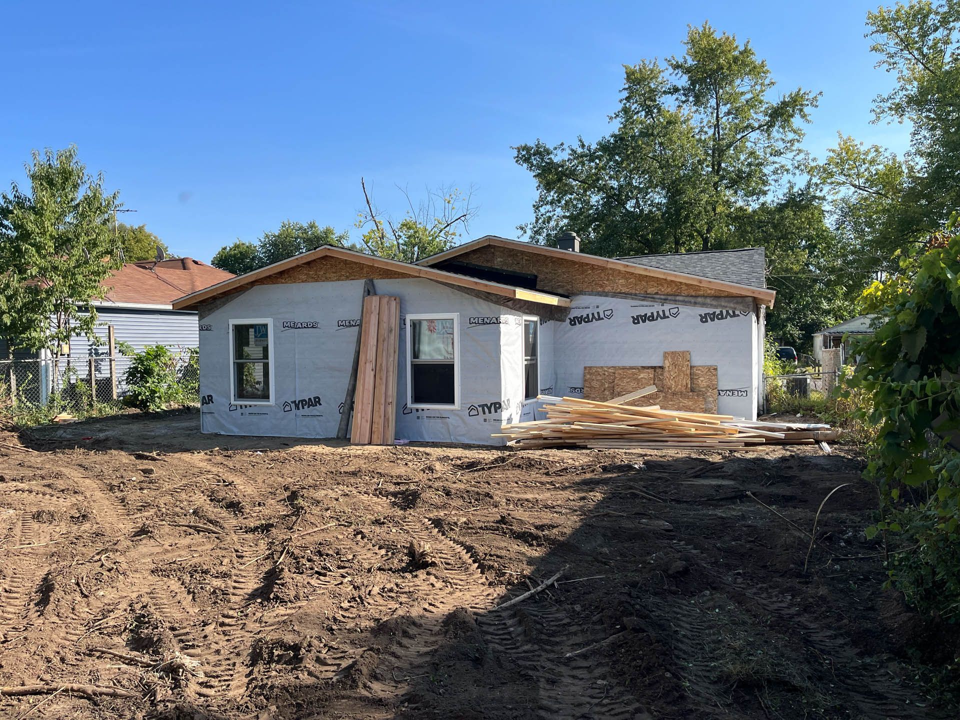 A house is being built in the middle of a dirt field.