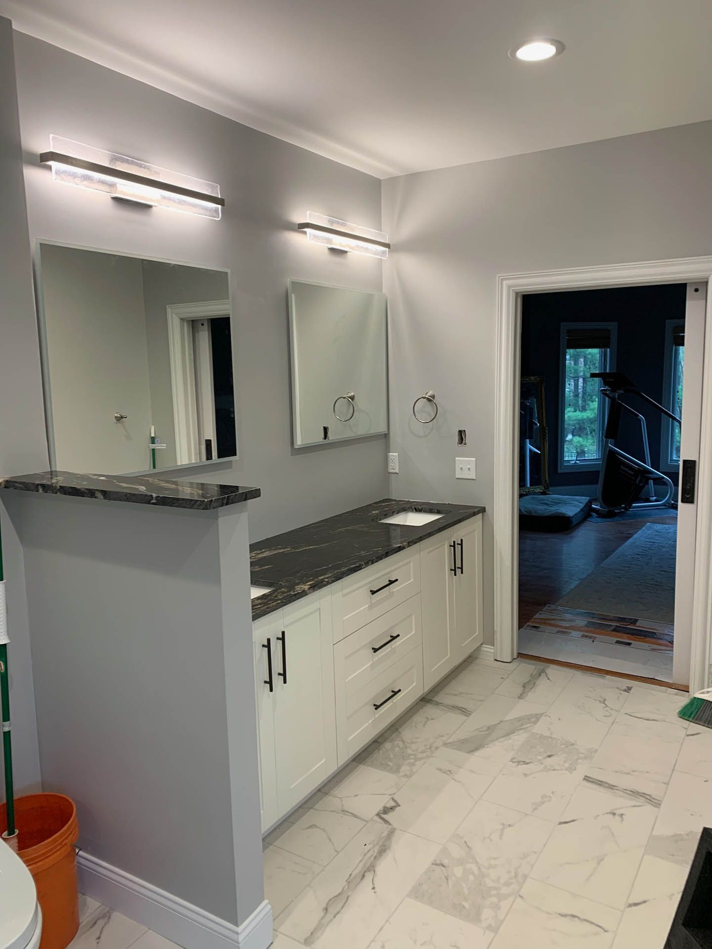 A bathroom with two sinks , a mirror and a toilet.