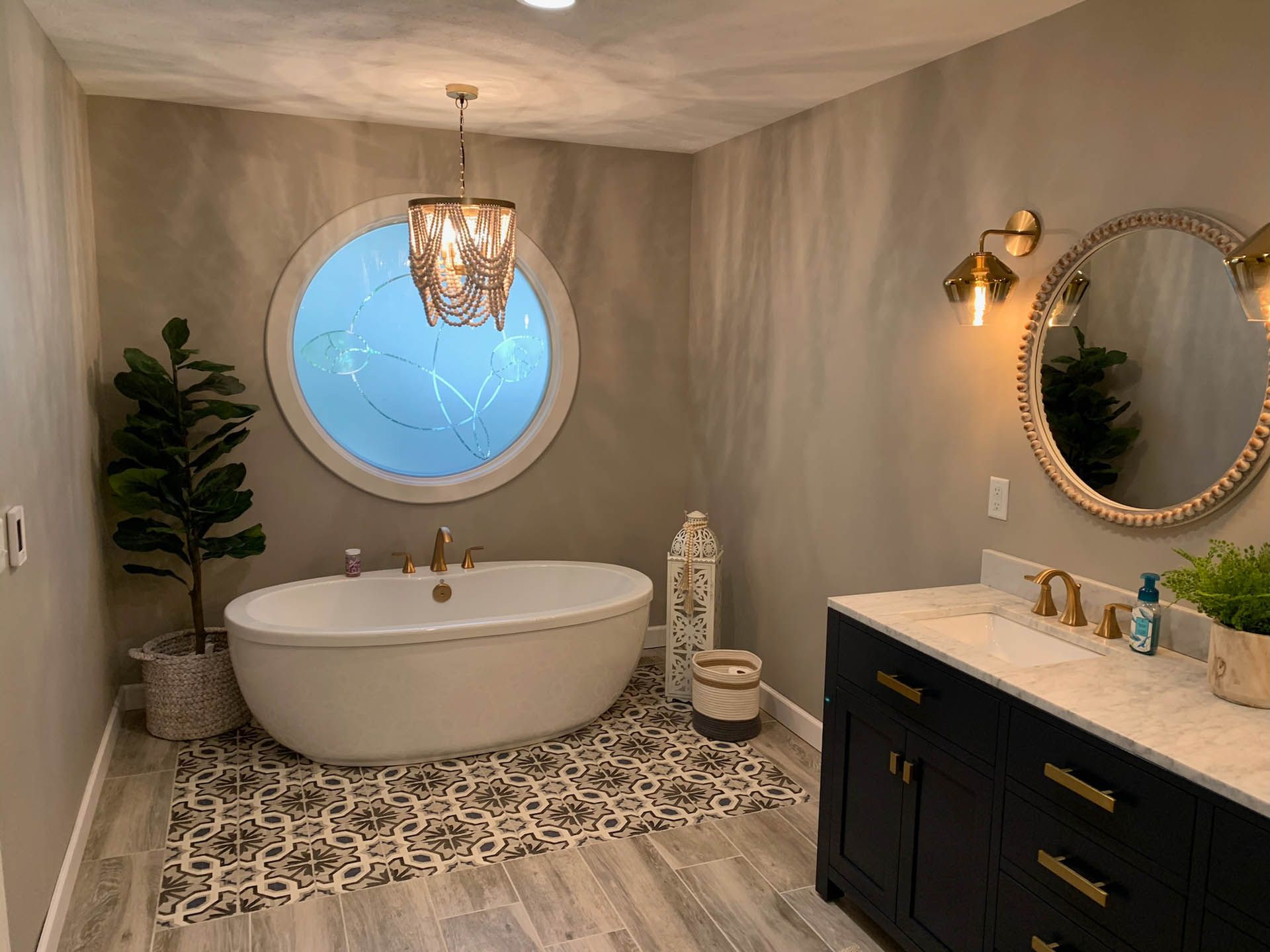A bathroom with a tub , sink and mirror.