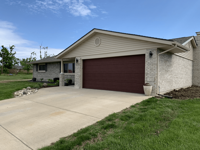 A house with a red garage door and a driveway.