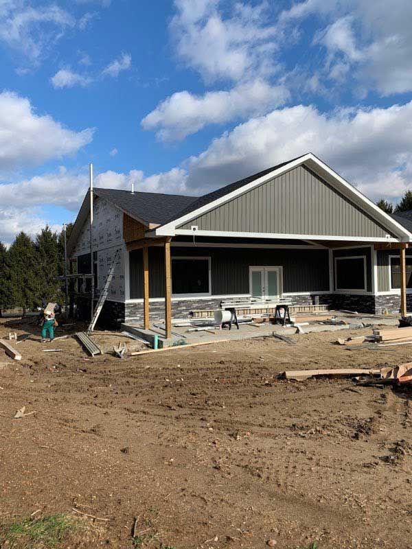 A house is being built in the middle of a dirt field.