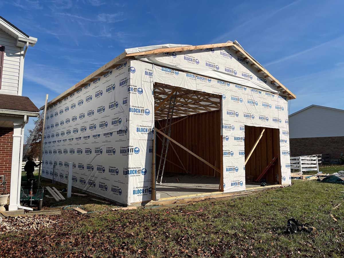 A garage is being built in the backyard of a house.