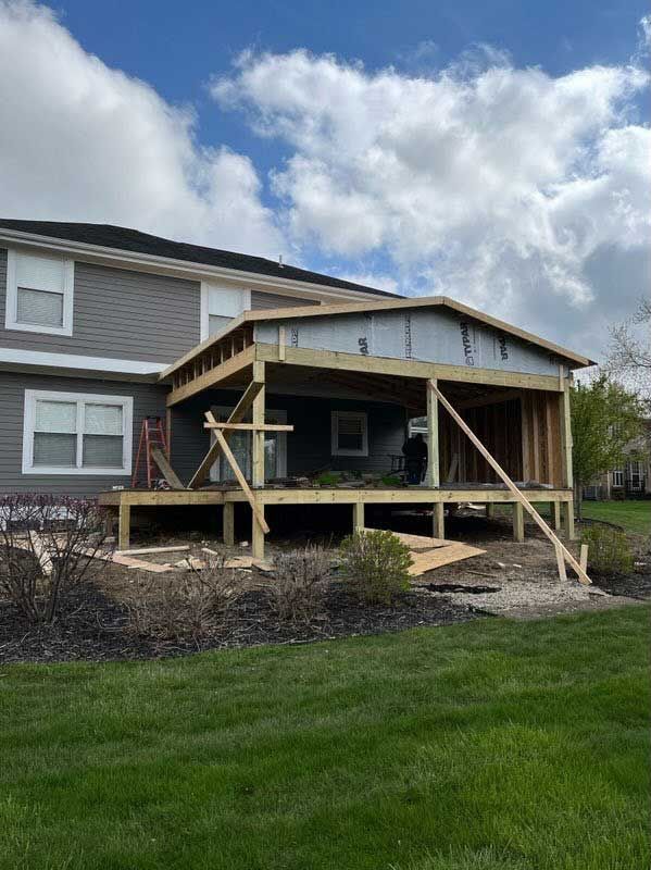 A house with a deck being built on top of it.