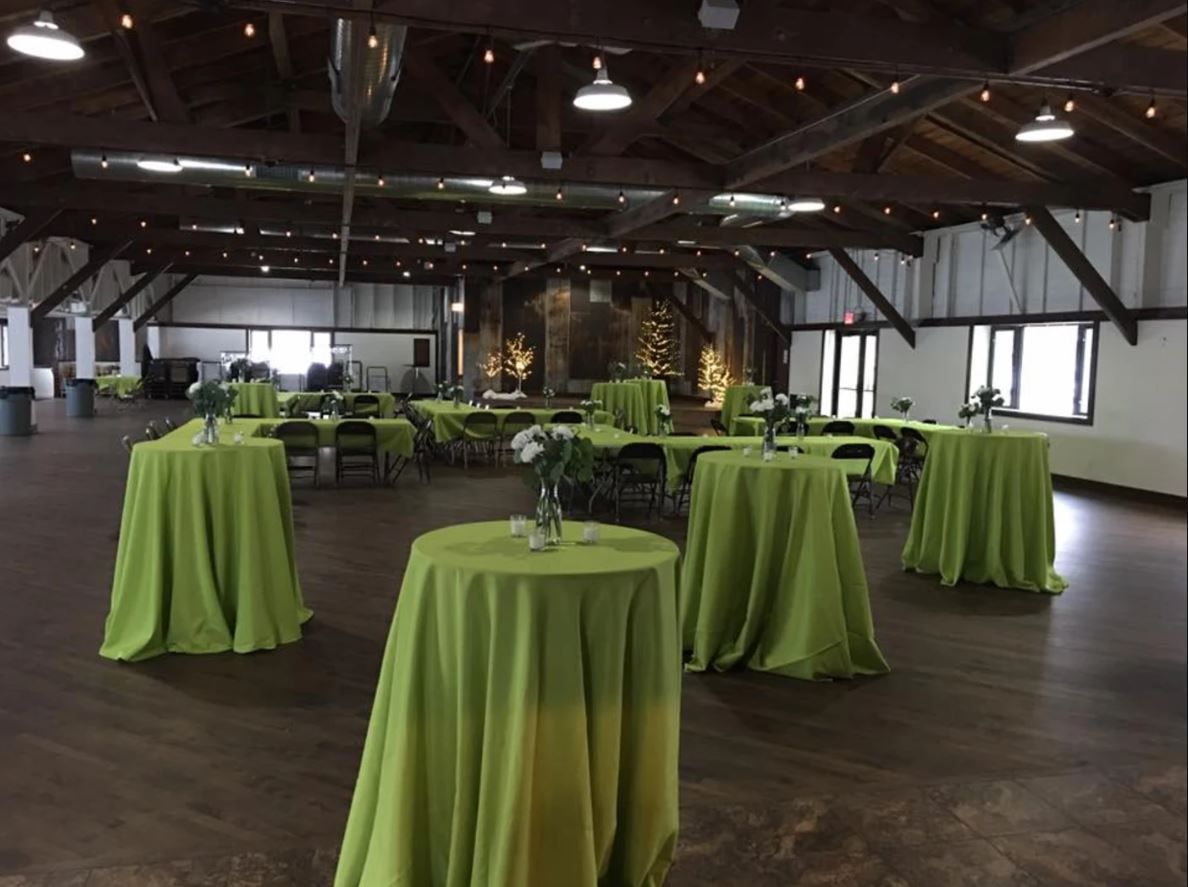 A long table with plates and napkins on it is set up for a wedding reception.