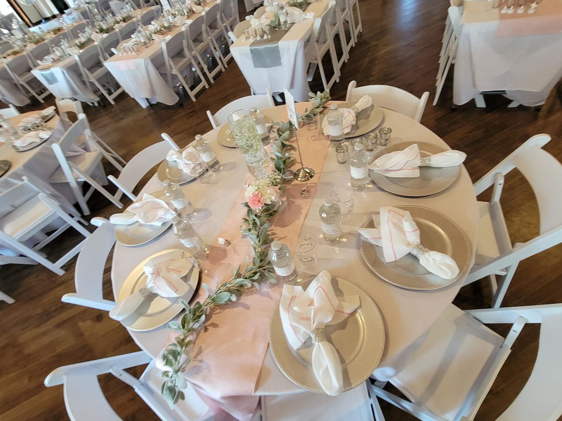 A large room with tables and chairs for a wedding reception.