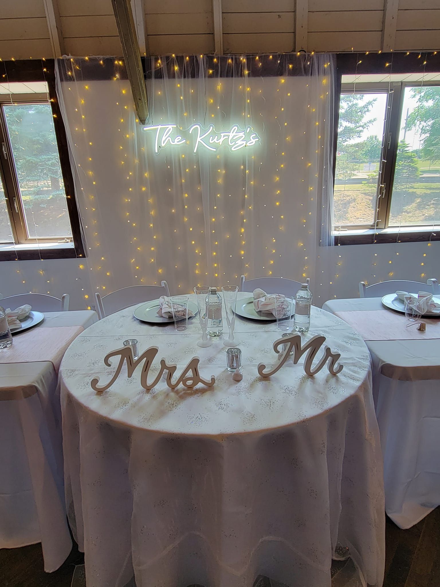 A table with a white tablecloth and a sign that says mr. and mrs. on it.