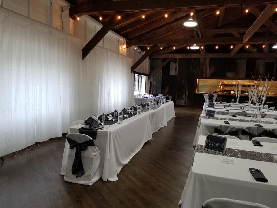 A large room with tables and chairs set up for a wedding reception.