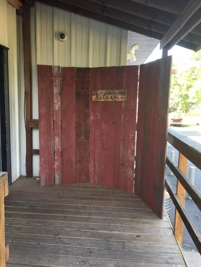 A wooden porch with a red fence and a sign that says texas