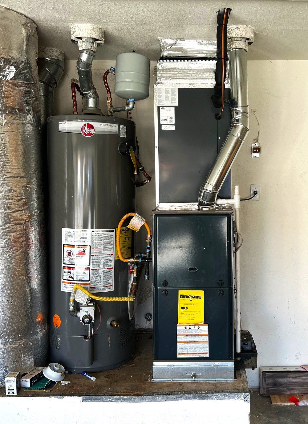 A water heater and an air conditioner are sitting next to each other in a room.