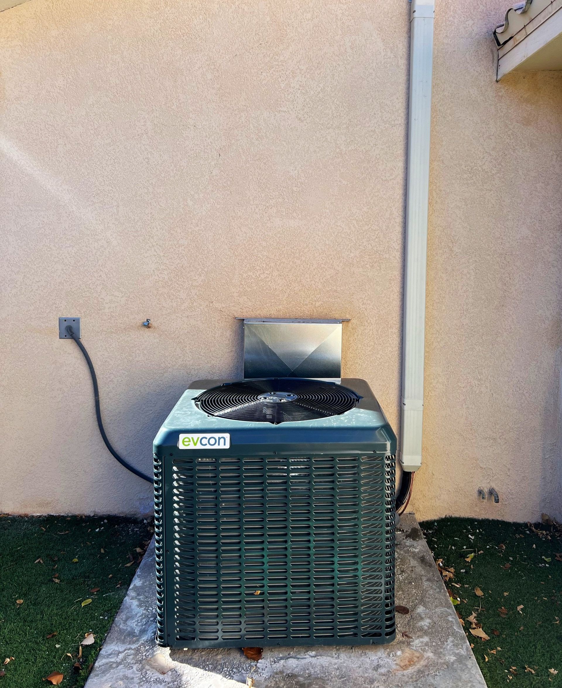 An air conditioner is sitting on the side of a building.