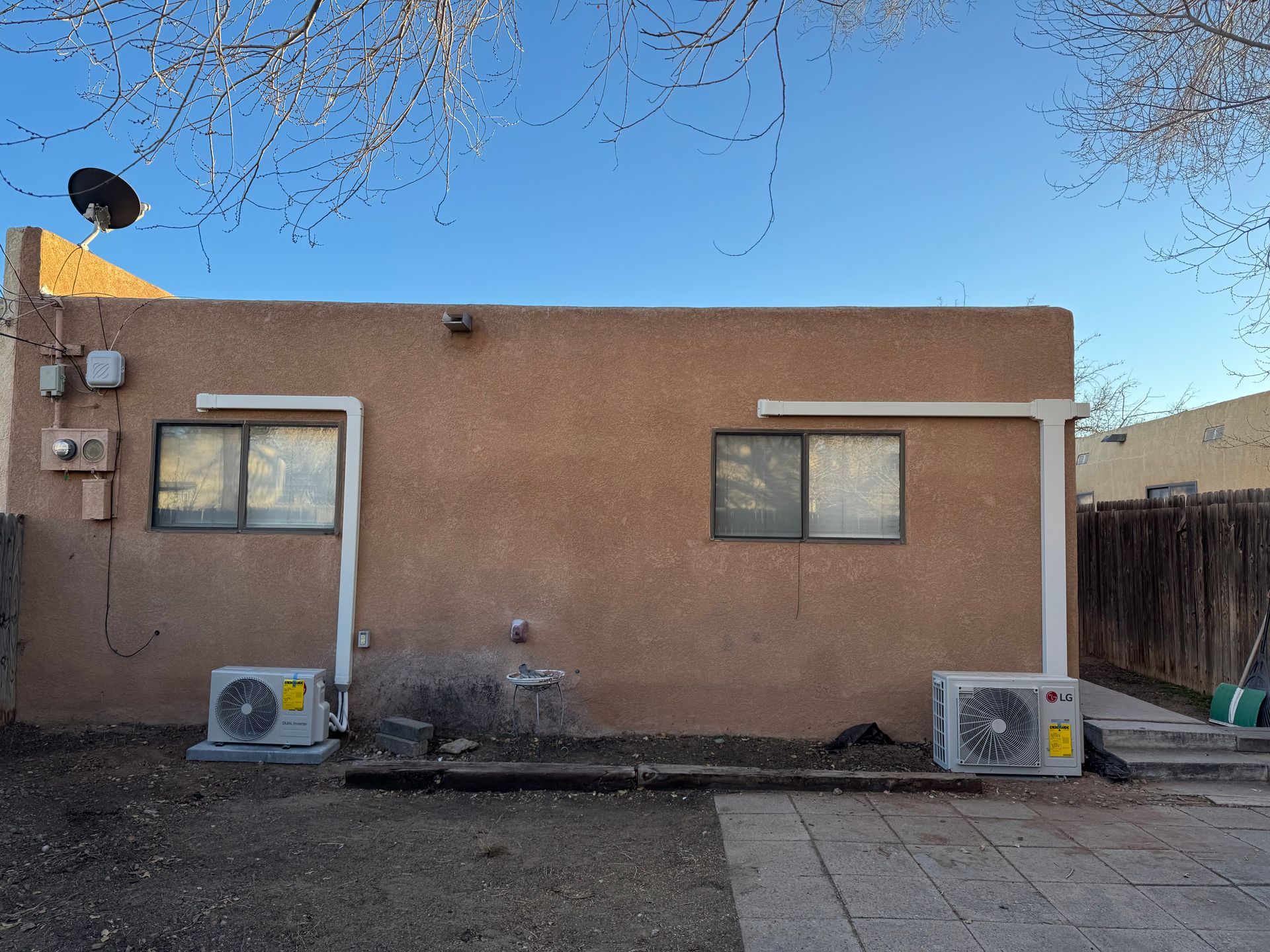 A house with two air conditioners on the side of it.