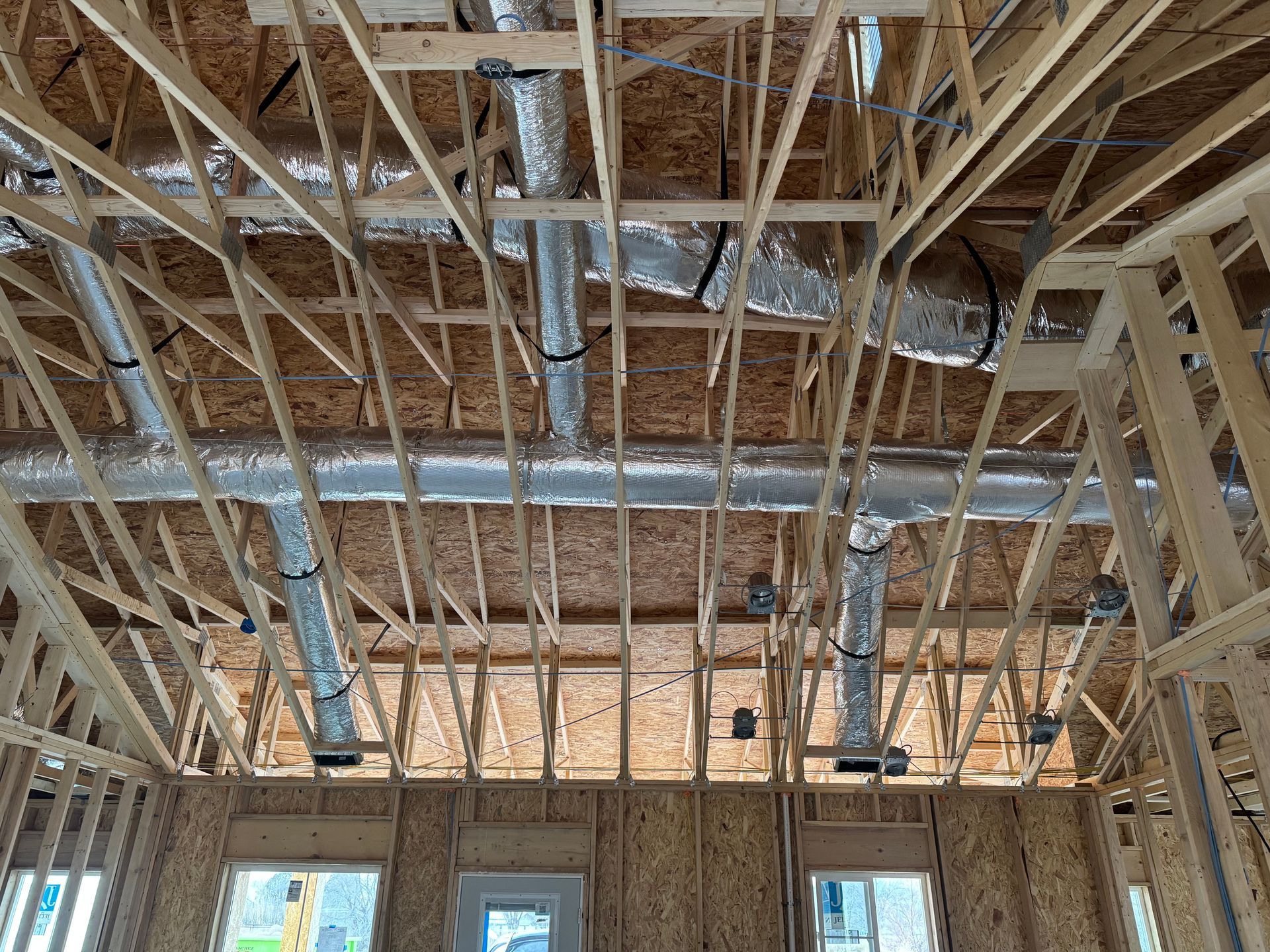The ceiling of a building under construction with a lot of pipes coming out of it.