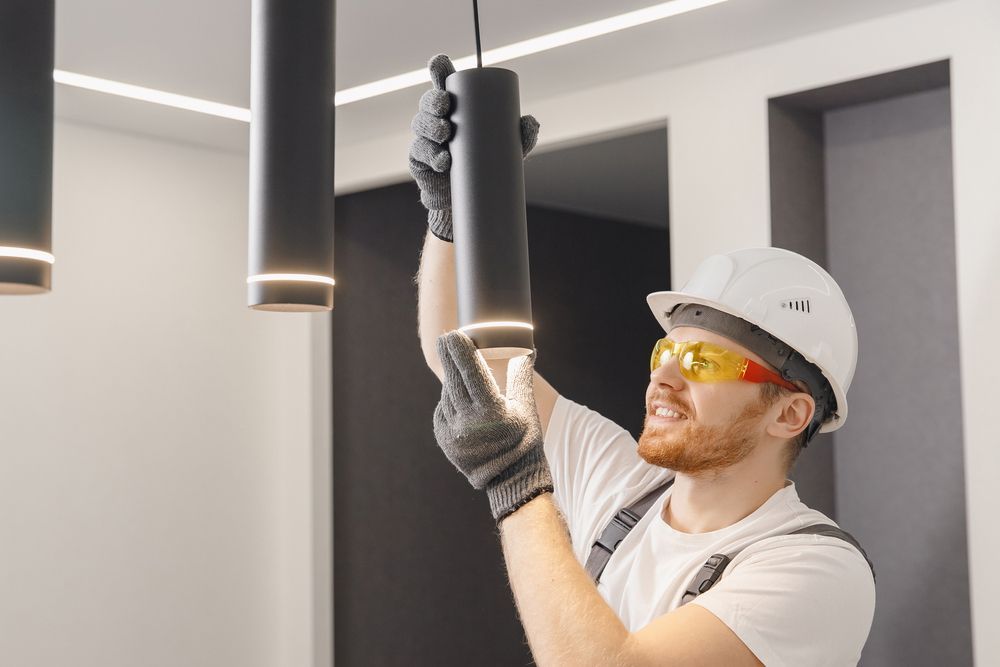 A man is installing a light fixture in a room