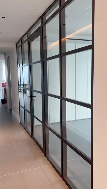 large conference deskwith chairs in a clear glass office with a frme of a woman with flowers on hr head in the background