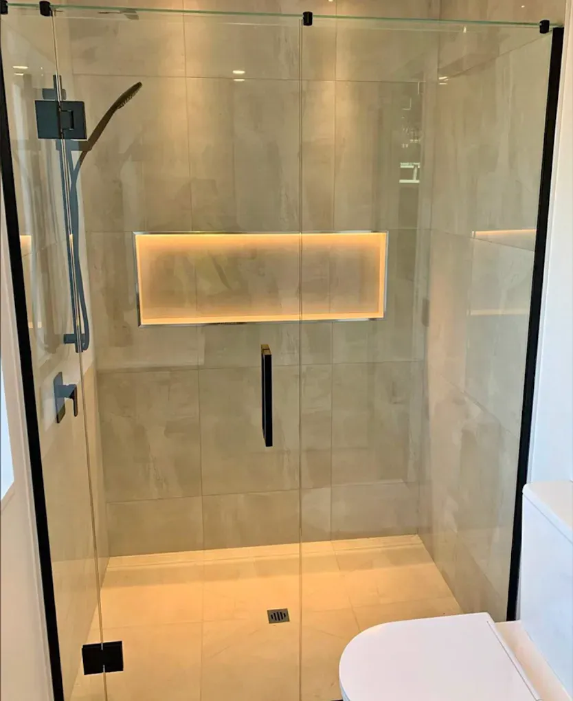 Cabina de ducha sin marco de vidrio templado instalada como parte de una remodelación de baño en Brickell.