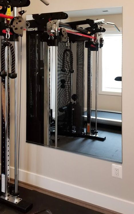 Wall mounted mirror with gym equiment reflected.