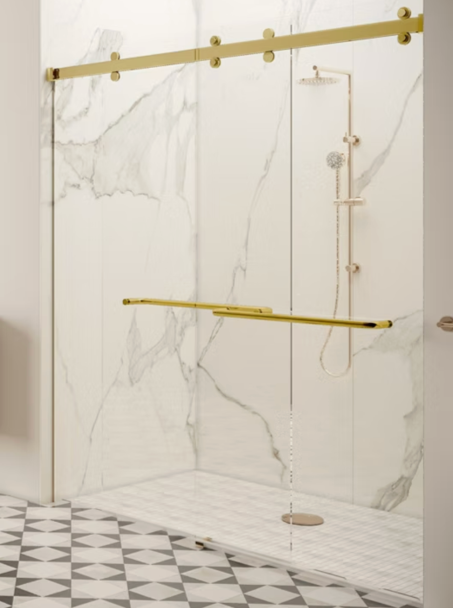 Gold-framed glass shower with marble-patterned walls and a checkered floor. Includes showerhead and grab bar.