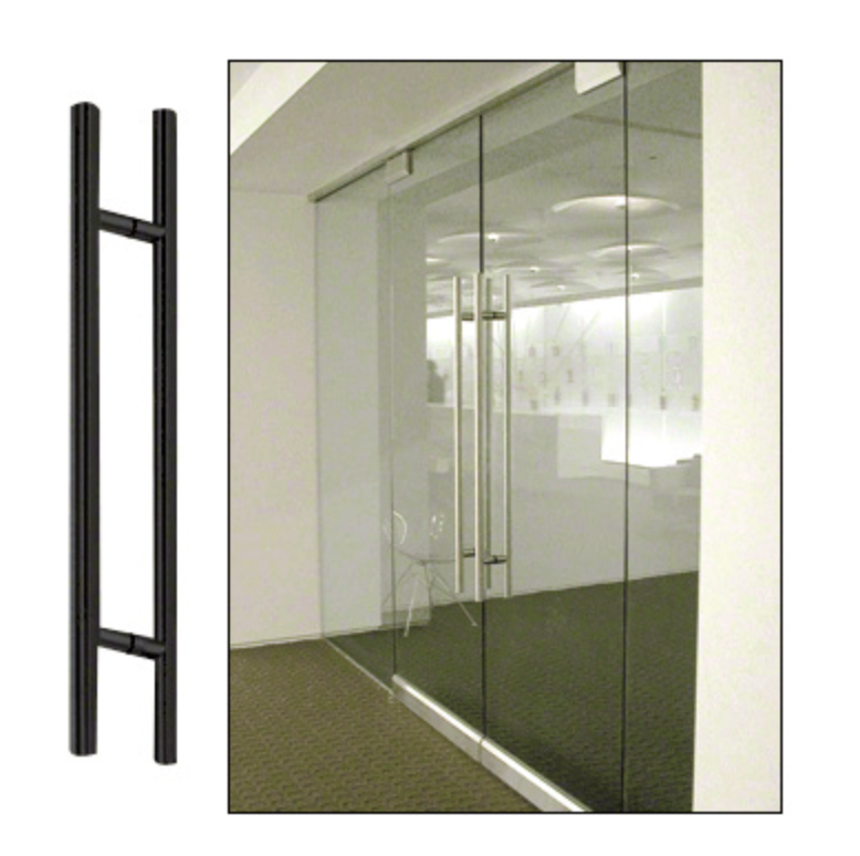 Black door pull handle next to glass door in an office setting.