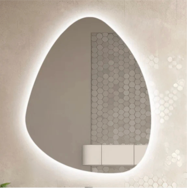 Abstract, illuminated mirror in a bathroom with neutral-toned walls and hexagon tile accents.