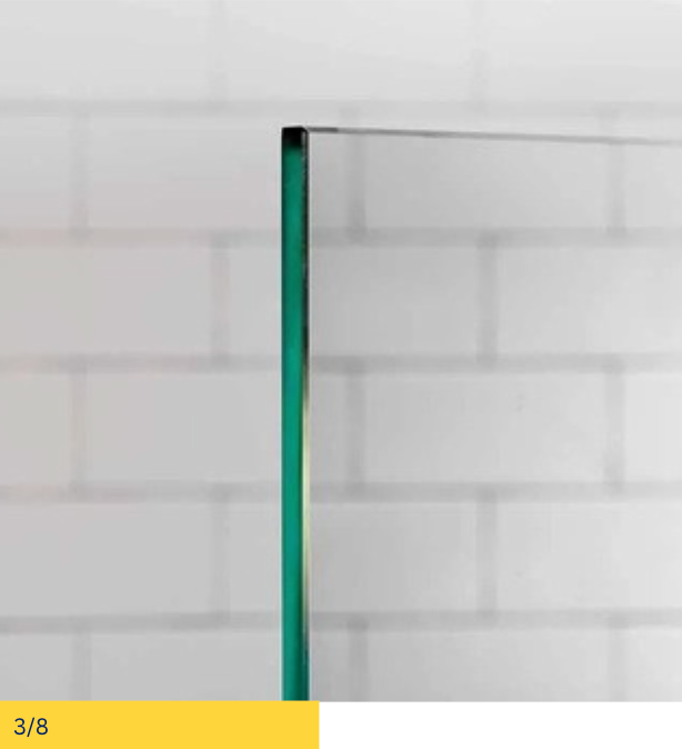 Close-up of a clear glass panel with a green tint, against a white tile background.