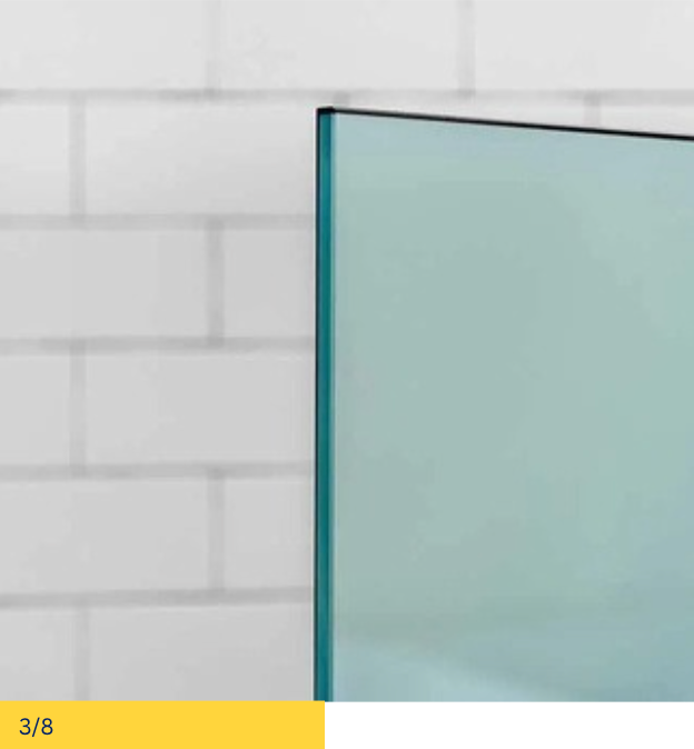 Glass panel with black trim against a white brick wall.