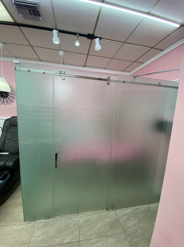 Frosted glass sliding door in a pink-walled spa.