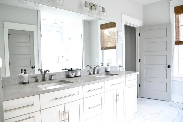 Rectangular mirror above a white vanity table with makeup items.