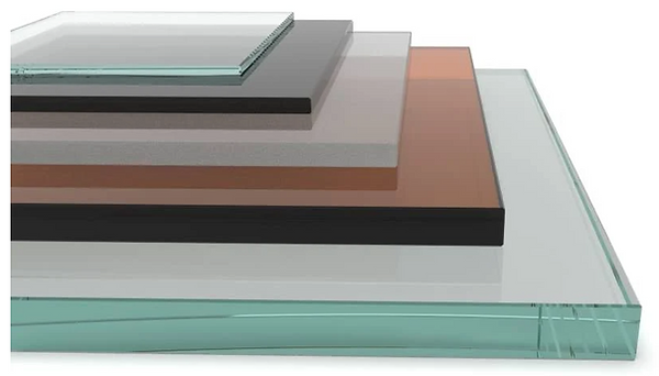 Stacks of tinted glass sheets in various shades of clear, gray, and bronze.
