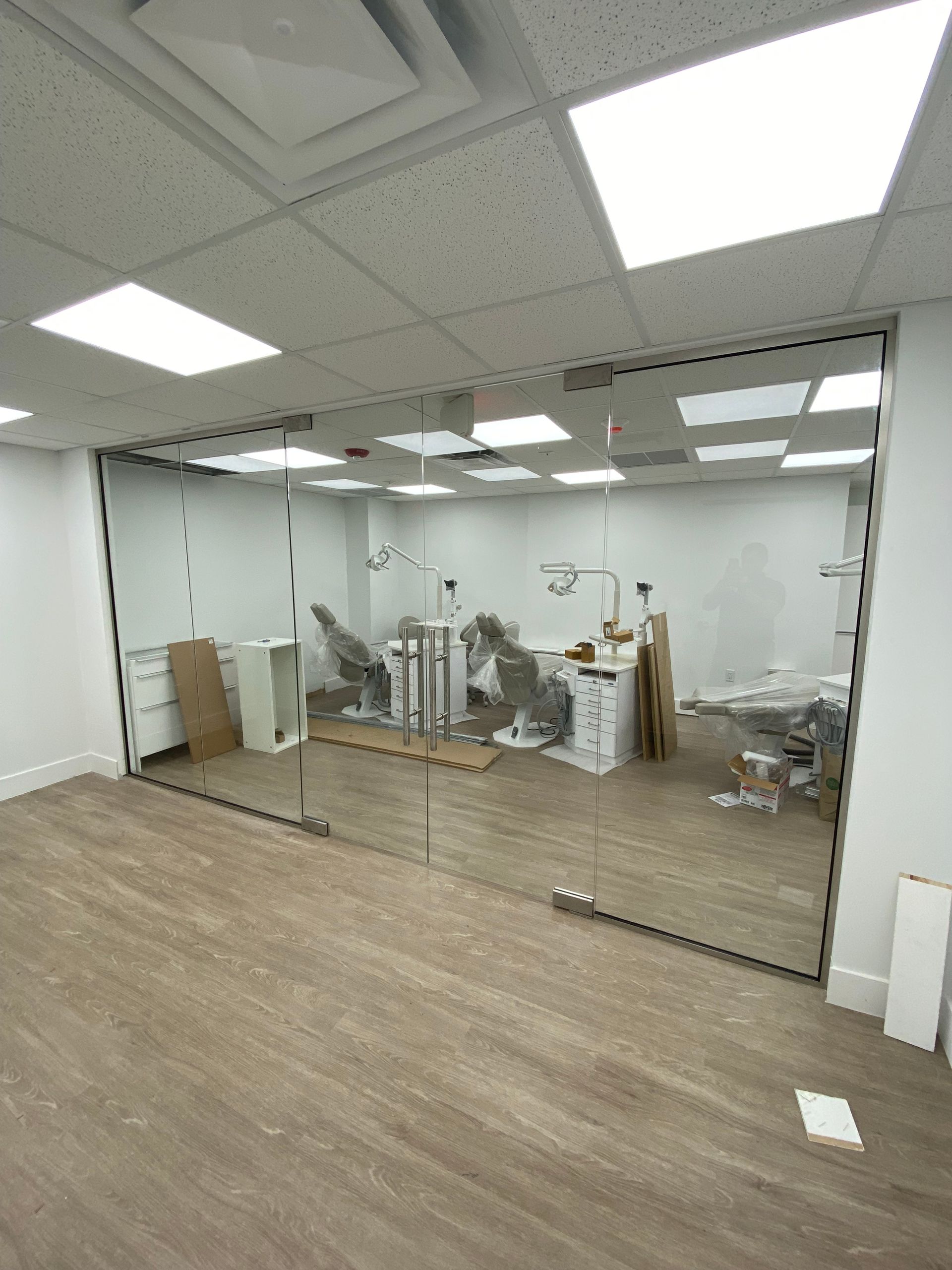 Channel Stylefull glass aentrance door with two sid epanels and dental equipment in the background