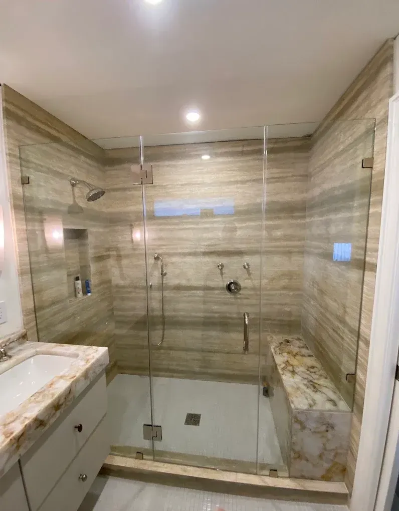 Puerta de ducha de vidrio sin marco instalada durante una remodelación de baño en Kendall.