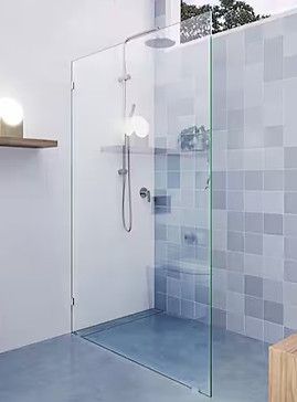 Glass shower enclosure with gray tiled wall and light fixtures.